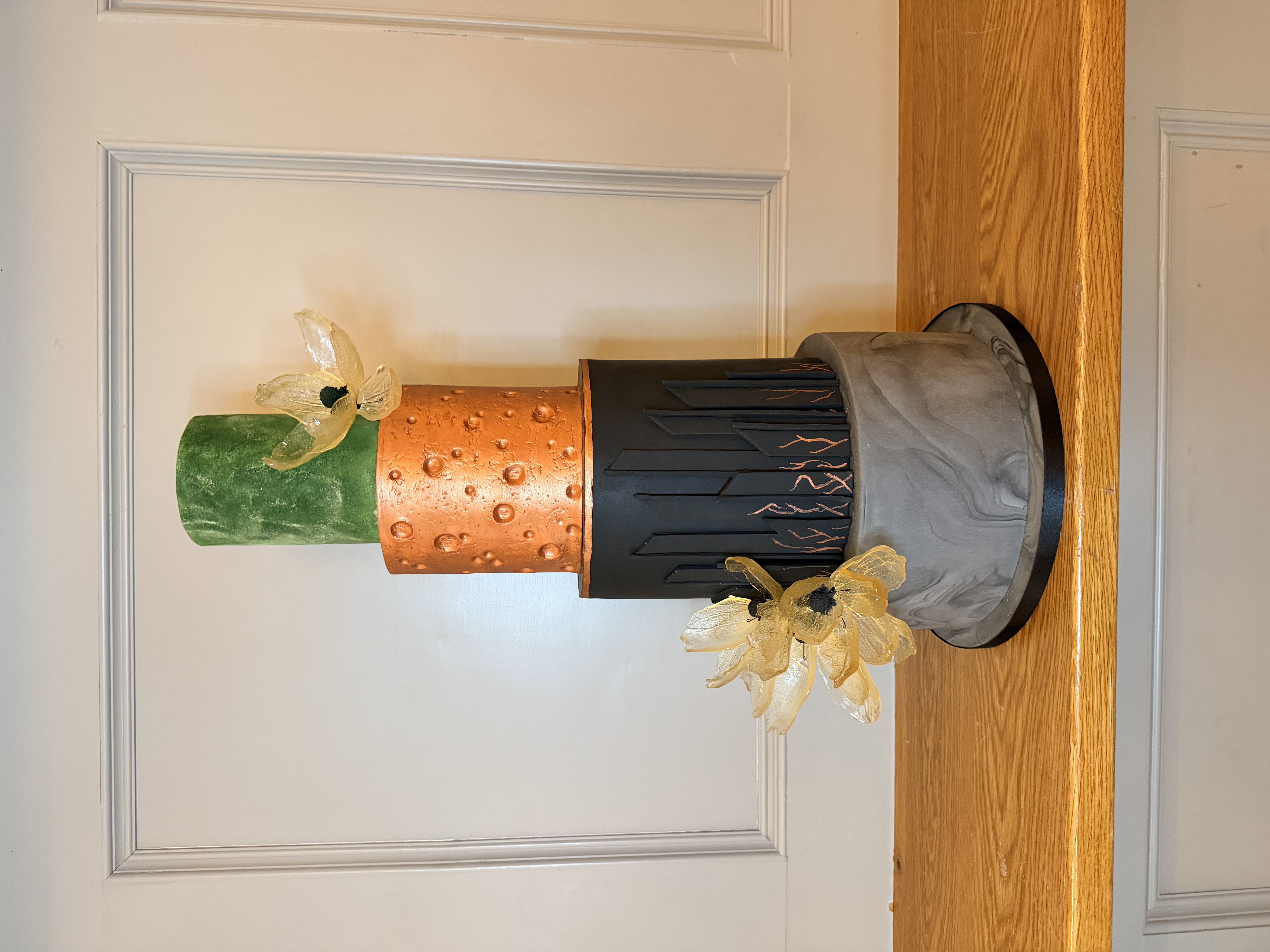 Industrial elegance meets contemporary design. This commission features a textured copper finish and sharp, architectural black tiers. — Crumbdidilyumptious, Glenrothes, fife