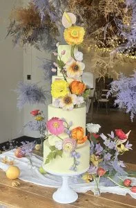 A vibrant sculptural centrepiece featuring hand-crafted sugar flowers in a modern, garden-inspired palette. — Crumbdidilyumptious, Glenrothes, fife